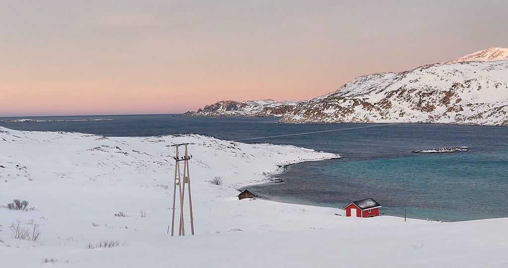 Referansefoto fra Nordmannset ved Mehamn i Finnmark som viser vinterlandskap med rødt hus ved fjorden og snødekte fjell