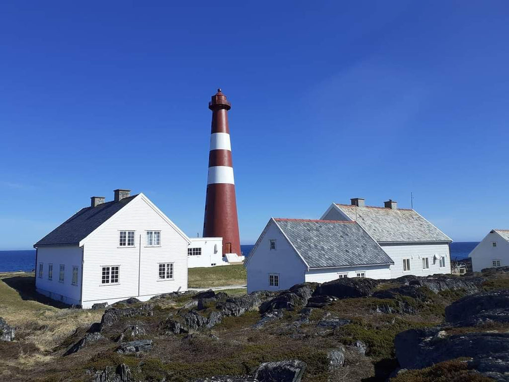 Slettnes fyr i Finnmark med hvite hus og fyrtårn i klart sommervær ved kysten