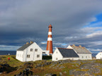 Slettnes fyr i Finnmark med hvite hus og fyrtårn i klart sommerlys ved kysten