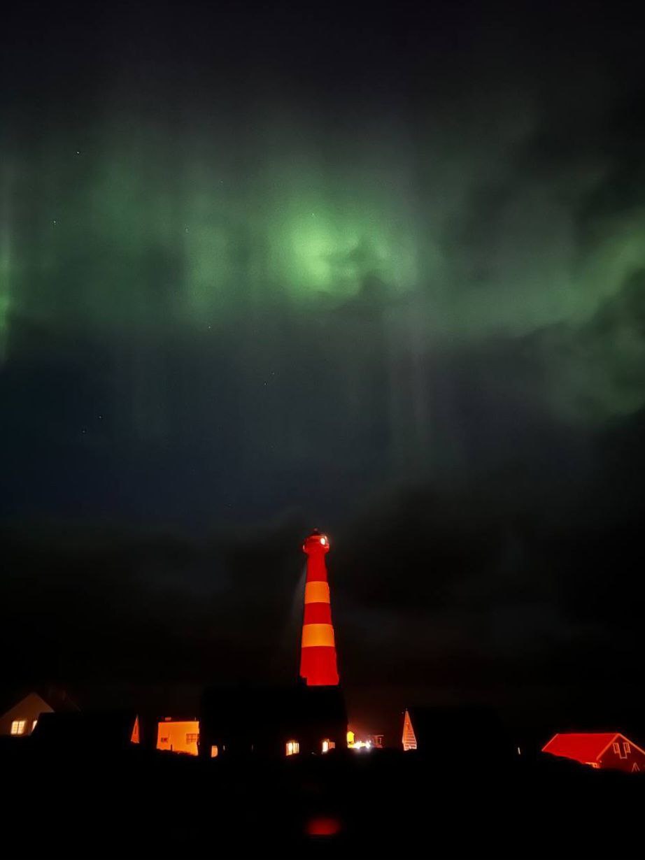 Slettnes fyr i Finnmark med nordlys over himmelen og fyrtårn i vintermørket